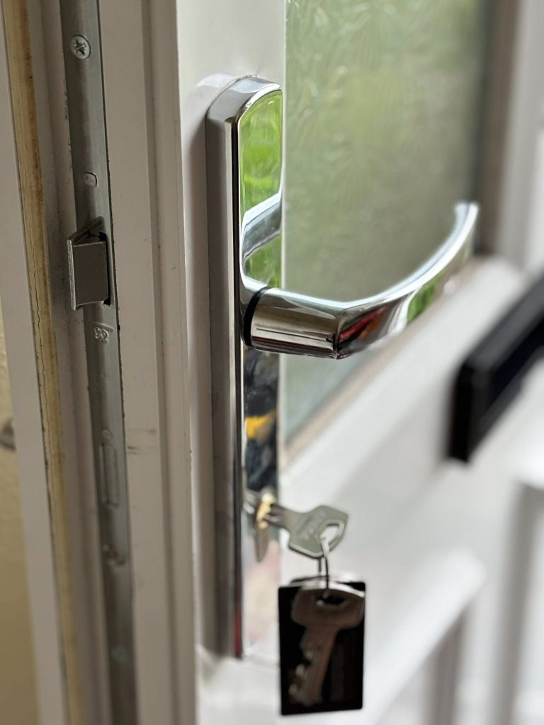 Side view of a multipoint locking unit installed on a door with keys in
