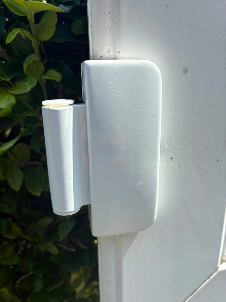 Close-up of a new white UPVC door flag hinge fitted to correct stack height during a door repair in Portslade.